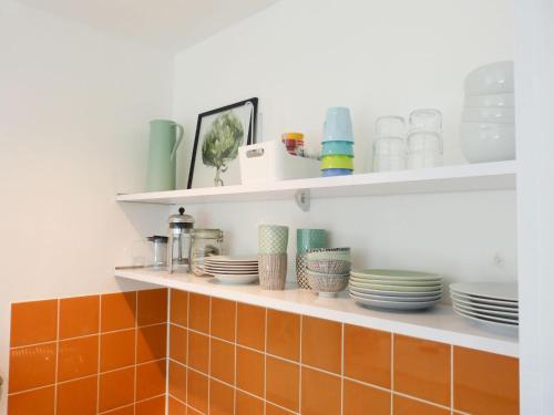 a shelf with plates and dishes on it at Ferienwohnung *Krabbe 25* in Wittdün