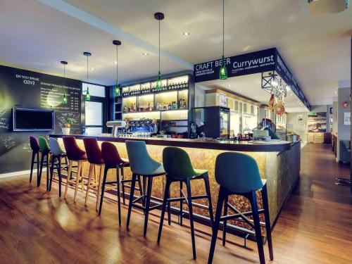 a bar with chairs and a counter in a restaurant at Mercure München City Center in Munich