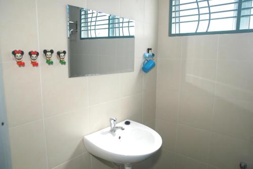 a white bathroom with a sink and a mirror at Qstay Sitiawan Townhouse (Minnie Dreams) - 米妮梦 in Sitiawan
