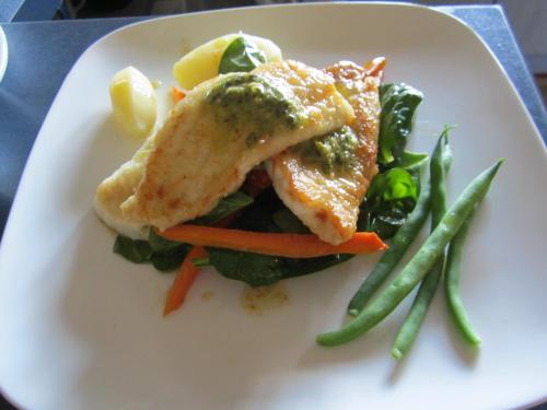 a white plate with a piece of fish and vegetables at Hawkdun Rise Vineyard & Accommodation in Alexandra