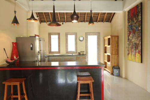 a kitchen with a black counter and a refrigerator at Bamboo Moon Villas in Sanur