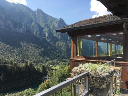 a house with a balcony with a view of mountains at albergo panoramico in Lenna