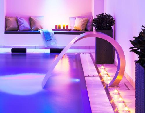 a pool in a room with a purple and purple lighting at Logierhus Langeoog in Langeoog