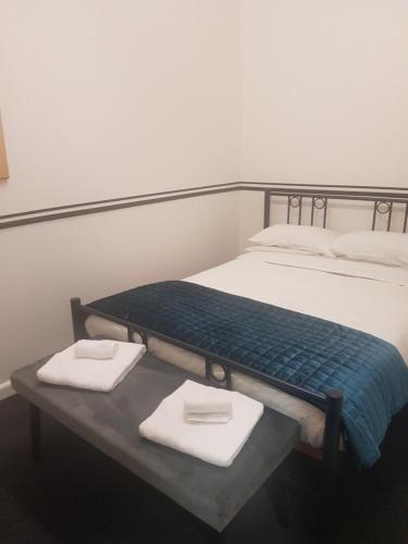 a bed with two folded towels on a table at Archies Bunker Affordable Accommodation in Napier