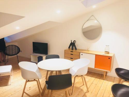 ラ・ロシェルにあるL'AppaRtのテーブル、椅子、鏡が備わる客室です。
