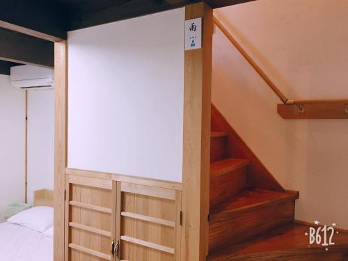 ajar door in a room with a stair case at Akitsuki Kominka Yado You in Asakura