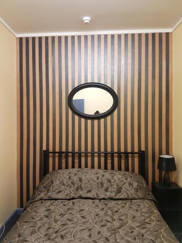 a bedroom with a bed and a round mirror at Archies Bunker Affordable Accommodation in Napier