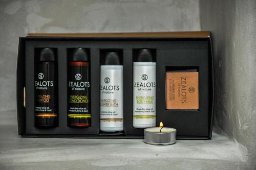 a black shelf with a group of bottles of soap and a candle at Andria's suites in Chrissi Akti