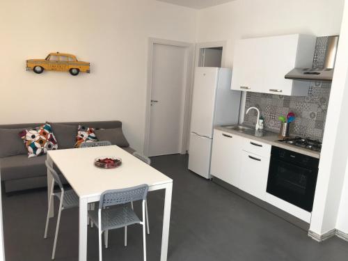 a small kitchen with a white table and a kitchen with a couch at Riviera lanterna in Scoglitti