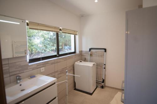 a bathroom with a white refrigerator and a window at Gite Guillemin in Le Deschaux