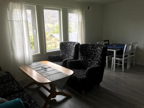 a living room with two chairs and a table at Fjordgård B in Tofta