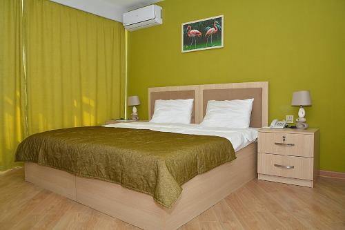 um quarto com uma cama grande e paredes verdes em Flamingo Hotel Baku em Baku