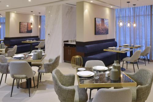 a dining room with tables and chairs and tablesktop at Swiss-Belresidences Juffair in Manama