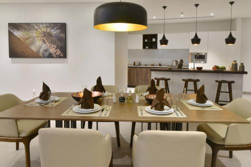a dining room with a wooden table and chairs at Swiss-Belresidences Juffair in Manama