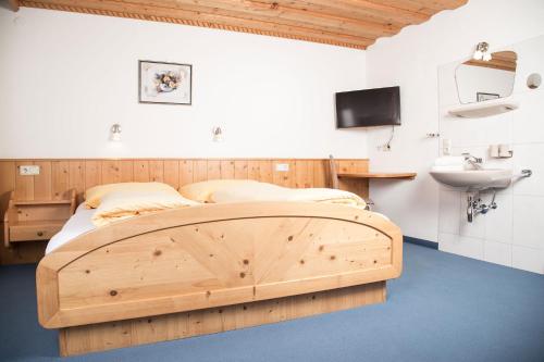 a bedroom with a wooden bed and a sink at Landhaus Maria in Neustift im Stubaital
