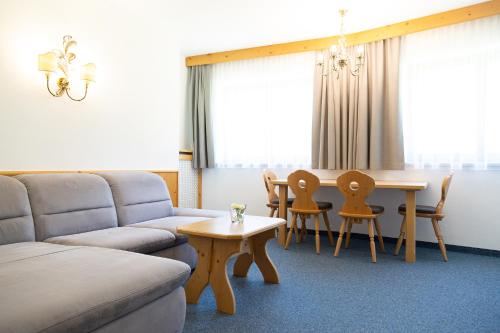 sala de estar con sofá, mesa y sillas en Pension Peter, en Neustift im Stubaital