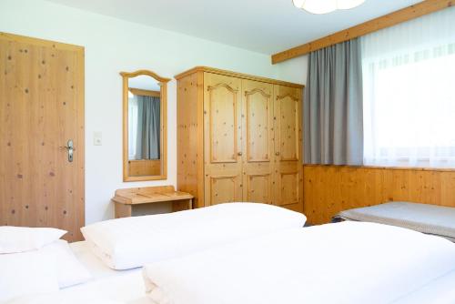 une chambre avec deux lits et une fenêtre dans l'établissement Pension Peter, à Neustift im Stubaital
