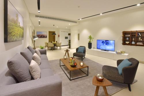 a living room with a couch and chairs and a tv at Swiss-Belresidences Juffair in Manama