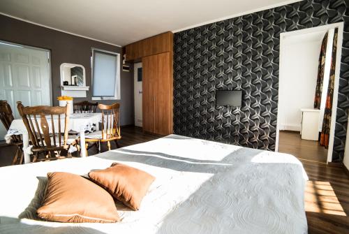 a bedroom with a large bed and a dining room at Na Poczatku - Apartamenty i Pokoje in Darłowo
