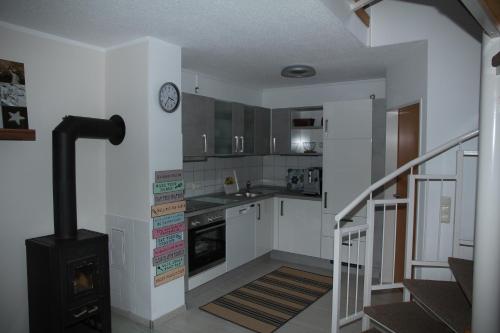 a small kitchen with a stove and a staircase at Ferienhaus LIVI in Zandt