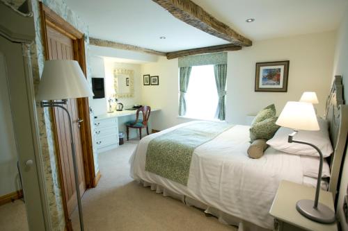 a bedroom with a bed with two lamps and a desk at The Black Swan in Glazebrook