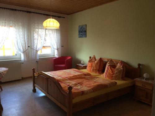 Kapellen-DrusweilerにあるWeingut & Gästehaus Nagelのベッドルーム1室(ベッド1台、赤い椅子付)