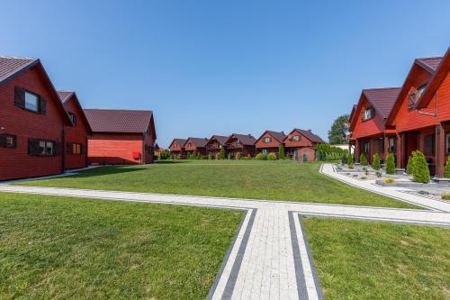 a walkway in front of a row of red houses at Domki Letniskowe Błękit in Jastrzębia Góra