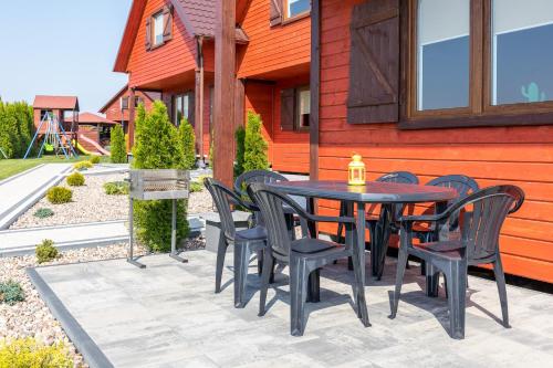 a black table and chairs on a patio at Domki Letniskowe Błękit in Jastrzębia Góra