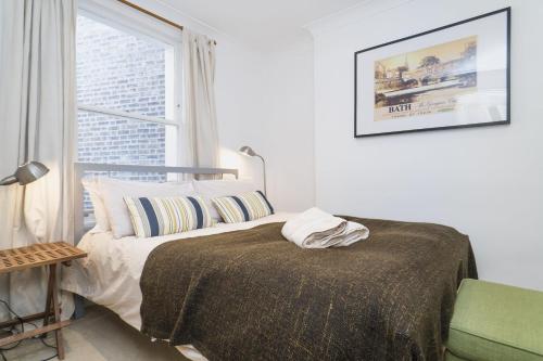 ロンドンにあるQuiet 1 Bed Apartment Pimlicoの白いベッドルーム(ベッド1台、窓付)