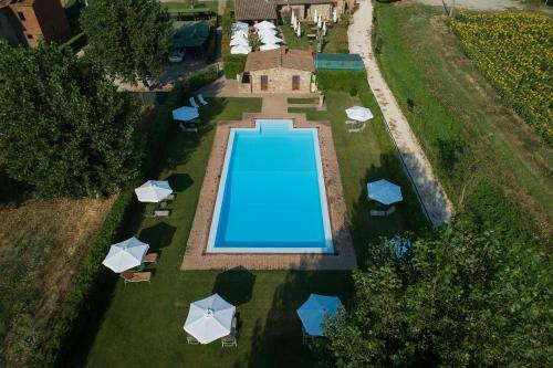 uma vista superior de uma piscina num quintal com guarda-sóis em Hotel Le Capanne em Arezzo