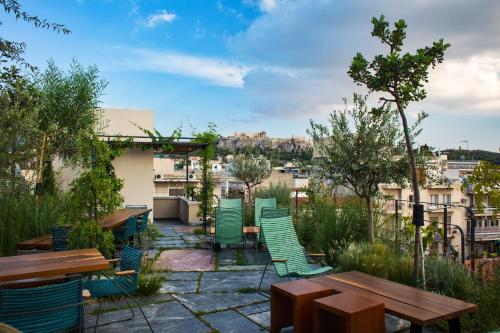 a patio with wooden tables and green chairs at The Foundry Suites in Athens