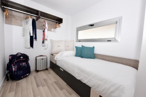 a bedroom with two beds and a backpack and a window at Beyond Amadores C&H Suite Nº4 in Amadores