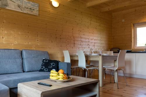 a living room with a couch and a table with a bowl of fruit at Domki Letniskowe Błękit in Jastrzębia Góra