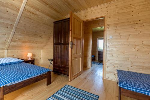 a log cabin with two beds and a closet at Domki Letniskowe Błękit in Jastrzębia Góra
