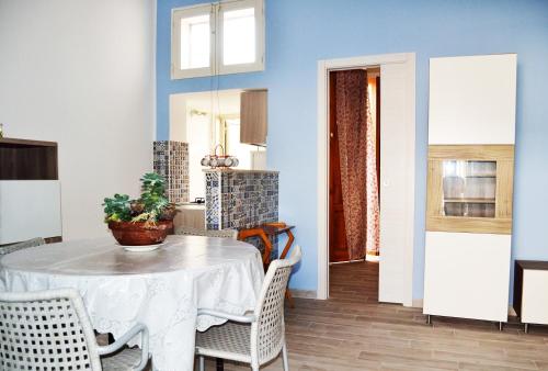a dining room with a white table and chairs at "Oriente Blu" a 400 mt dal mare in Scoglitti