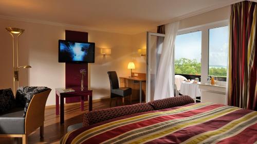 ein Hotelzimmer mit einem Bett und einem TV an der Wand in der Unterkunft Landidyll Hotel Restaurant Birkenhof in Klosterkumbd