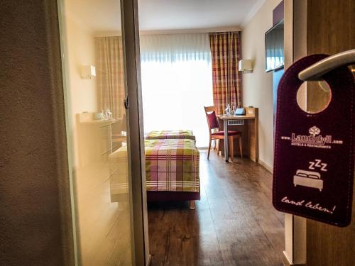 una habitación de hotel con una puerta que conduce a un dormitorio en Landidyll Hotel Restaurant Birkenhof en Klosterkumbd