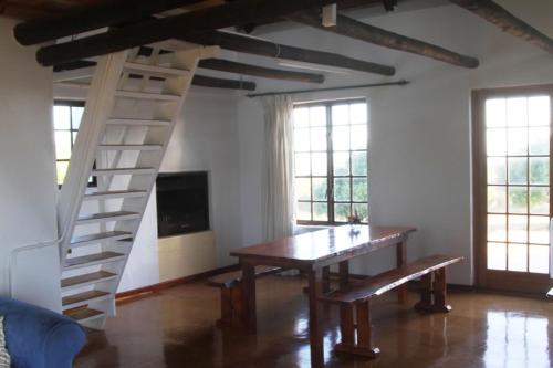 ein Esszimmer mit Tisch und Wendeltreppe in der Unterkunft Koensrust Sea Farm in Vermaaklikheid