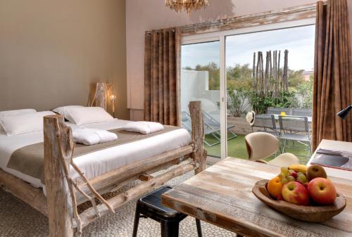 a bedroom with two beds and a table with a bowl of fruit at Vila De La Mar & Spa in Saintes-Maries-de-la-Mer