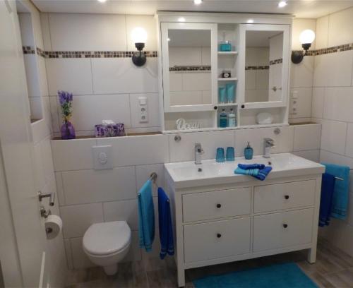 a white bathroom with a sink and a toilet at Ferienhaus Agnes in Ramberg