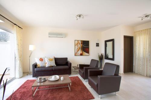 Club Coral View Resort في بييا: غرفة معيشة مع أريكة وكراسي وطاولة
