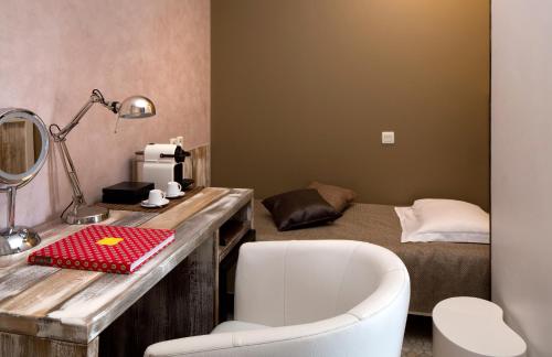 a bedroom with a bed and a desk with a mirror at Vila De La Mar & Spa in Saintes-Maries-de-la-Mer