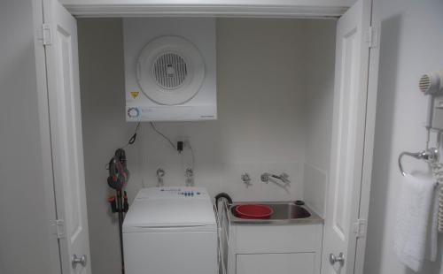a small kitchen with a sink and a fan at FortyTwo - Oceanside Retreat Busselton in Busselton