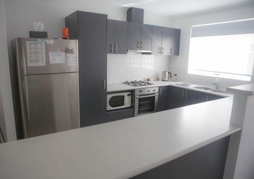a kitchen with a refrigerator and a counter top at FortyTwo - Oceanside Retreat Busselton in Busselton