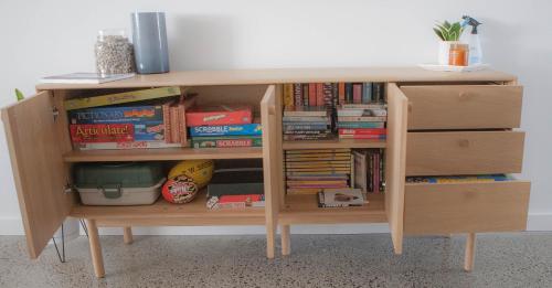 a wooden book shelf with books on it at FortyTwo - Oceanside Retreat Busselton in Busselton