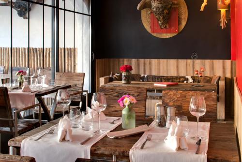 a restaurant with tables with white tablecloths and wine glasses at Vila De La Mar & Spa in Saintes-Maries-de-la-Mer