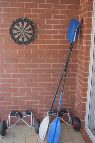 two golf carts against a brick wall with a clock at FortyTwo - Oceanside Retreat Busselton in Busselton