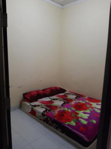 a bedroom with a bed with a colorful comforter at Nusantara kost syariah bulanan harian in Kalasan