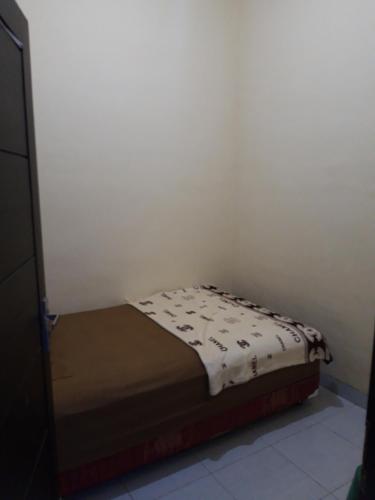 a small bed in a corner of a room at Nusantara kost syariah bulanan harian in Kalasan
