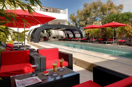 - une piscine avec des chaises longues et des parasols à côté de la piscine dans l'établissement Vila De La Mar & Spa, à Saintes-Maries-de-la-Mer